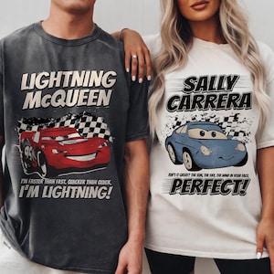 May include: Two t-shirts featuring characters from the movie Cars. One is dark gray with "LIGHTNING McQUEEN" and a red race car graphic. The other is white with "SALLY CARRERA" and a blue car graphic. Both shirts have text.