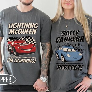 May include: Two gray t-shirts featuring characters from the movie Cars. One shirt has Lightning McQueen with the text "I'm faster than fast, quicker than quick, I'm Lightning!" The other has Sally Carrera with the text "Perfect!"