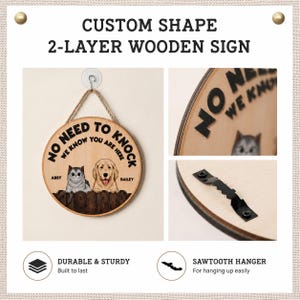 May include: A round two-layer wooden sign featuring the text NO NEED TO KNOCK WE KNOW YOU ARE HERE, with illustrations of a cat named Abby and a dog named Bailey behind a fence. The sign includes a jute rope for hanging and a black sawtooth hanger.