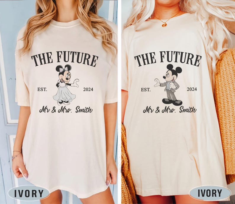Puede incluir: Dos camisetas de color marfil con un estampado gr&aacute;fico de Mickey y Minnie Mouse. El texto en las camisetas dice "The Future" con el a&ntilde;o "2024" y "Mr & Mrs. Smith".