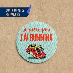 Peut inclure: Un badge rond avec le texte "je peux pas J'AI RUNNING" et une paire de chaussures de course. Le badge est bleu clair avec un motif en chevrons. Le texte "LES BADGES COLORÉS BOHÈME, POP, CHIC, FLEURI" est en haut.