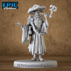 May include: A white painted miniature figurine of a humanoid figure with a mushroom-shaped hat, wearing a long robe and holding a pipe. The figure has a small creature on its shoulder and is standing on a round base with the text "3D Miniatures Factory".