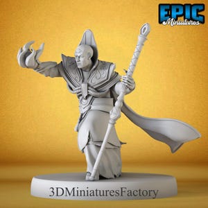 Puede incluir: Figura en miniatura gris de un mago con túnica, báculo y capa fluida. La figura está sobre una base redonda con el texto "3D Miniatures Factory". El logotipo de Epic Miniatures está en la esquina superior derecha.