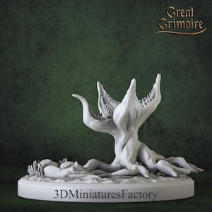 May include: A 3D printed miniature of a white, plant-like creature with multiple mouths. The creature is posed on a round base with the text "3D Miniatures Factory" printed on it. The creature appears to be attacking or consuming something off-screen.