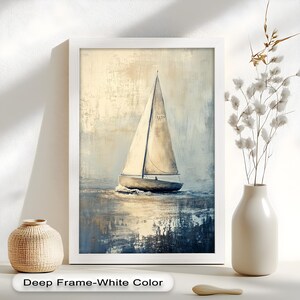 May include: A framed painting of a sailboat on the water. The artwork features a white sailboat with a tall sail, set against a muted background of blues and creams. The frame is white, and the text "Deep Frame-White Color" is at the bottom.