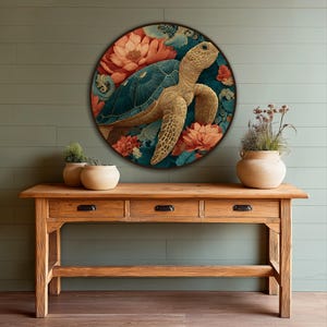 Puede incluir: Una obra de arte mural redonda que presenta una tortuga marina rodeada de flores color coral y follaje turquesa. La obra de arte se exhibe sobre una consola de madera con tres cajones y cerámica decorativa.