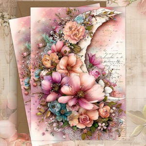 May include: Two greeting cards with a floral design. The cards feature a watercolor illustration of a crescent moon shape adorned with pink, peach, and purple flowers, with touches of blue and green. The background is a soft pink with script.