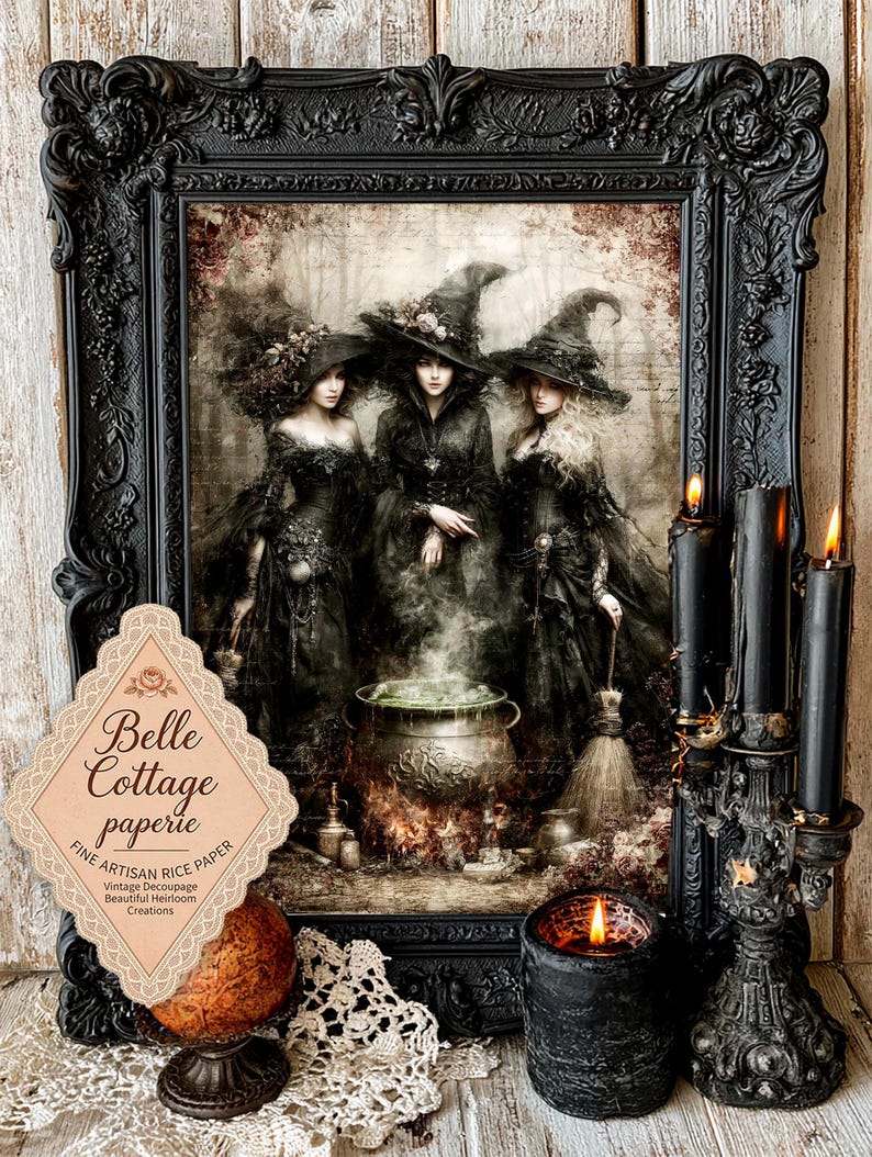 May include: A framed print featuring three figures in black pointed hats and dark dresses standing around a steaming cauldron. A label reads Belle Cottage paperie FINE ARTISAN RICE PAPER. Three black candles in a decorative holder sit nearby.