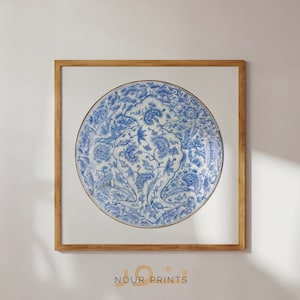 Puede incluir: Una impresión enmarcada de un plato de cerámica azul y blanco con un diseño floral. El plato está en un marco de madera y la impresión está sobre un fondo blanco.