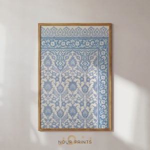Puede incluir: Una impresión enmarcada de un patrón floral azul y blanco con un diseño islámico tradicional. La impresión está en un marco de madera y tiene un fondo blanco.