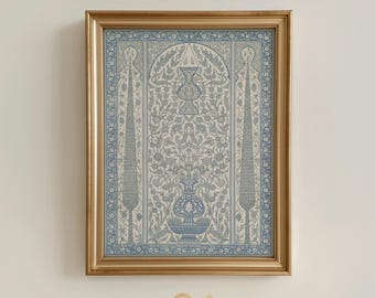 Puede incluir: Una impresión enmarcada con un detallado diseño floral azul y blanco, que incluye jarrones y árboles estilizados. La impresión está en un marco dorado e incluye el texto "NOUR PRINTS" en la parte inferior.