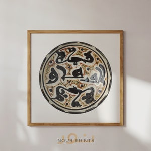 May include: A framed print of a round ceramic plate with intricate black and white calligraphy and orange and brown accents. The plate is decorated with a repeating pattern of small dots.