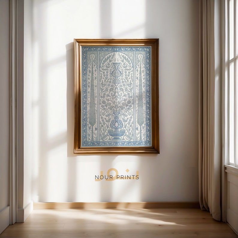 K&ouml;nnte beinhalten: Ein gerahmter Druck eines blauen und wei&szlig;en Blumenmusters mit einem traditionellen t&uuml;rkischen Muster. Der Druck ist in einem Holzrahmen und h&auml;ngt an einer wei&szlig;en Wand. Der Text "Nour Prints" ist unter dem Druck sichtbar.