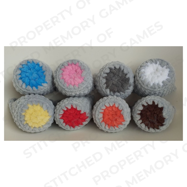 May include: Eight crocheted gray cones with different colored centers. The centers are blue, pink, gray, white, yellow, red, orange, and brown.