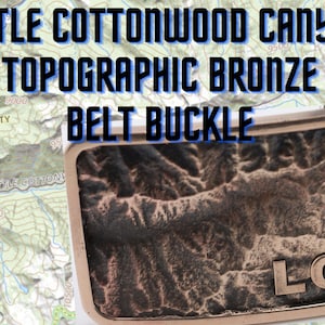 May include: A bronze belt buckle with a topographic map design of Little Cottonwood Canyon, Utah. The buckle has the letters "LCC" engraved on the bottom.