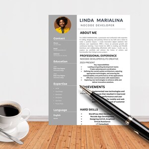 Puede incluir: Un currículum vitae para Linda Marialina, Desarrolladora Nocode, con foto, información de contacto, educación, experiencia y habilidades. Una taza de café y un bolígrafo sobre una superficie de madera.