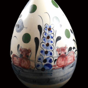 May include: A white ceramic egg-shaped vase with a blue, green, and red floral design and two red and white animal figures.