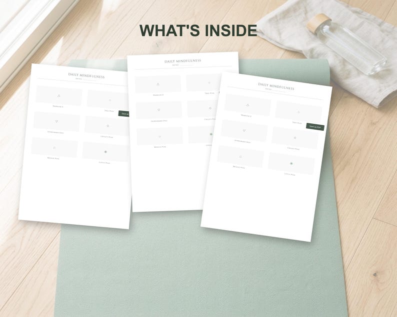 May include: Three white Daily Mindfulness worksheets are displayed on a light green yoga mat. The text "WHAT'S INSIDE" is at the top. A clear glass water bottle with a wooden cap rests on a white cloth.