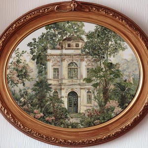 Puede incluir: Una obra de arte ovalada y enmarcada que presenta una pintura detallada de un edificio clásico rodeado de exuberante vegetación. El edificio tiene un techo abovedado y ventanas arqueadas. El marco es de madera con un diseño ornamental.
