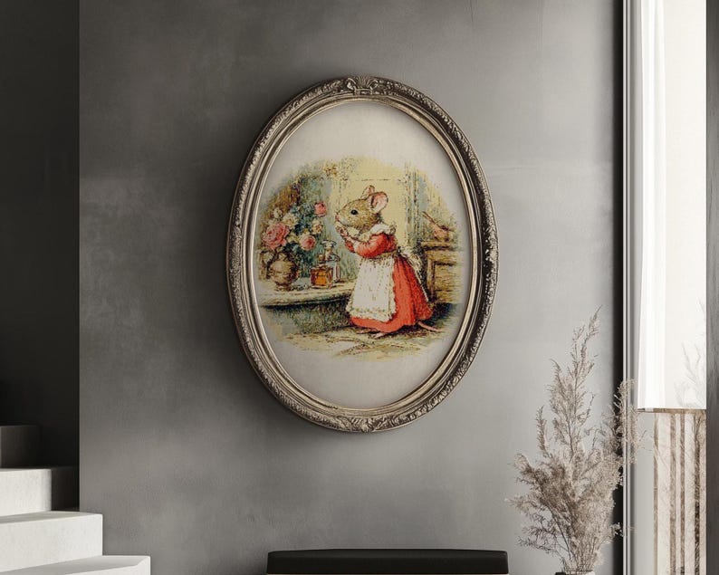 Pu&ograve; includere: Una stampa ovale incorniciata con un topo in un vestito rosso e un grembiule bianco, in piedi vicino a un vaso di fiori. La stampa ha una cornice ornata color argento. L'opera d'arte &egrave; esposta su un muro grigio.