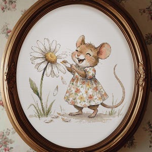 May include: A framed cross-stitch artwork features a smiling mouse in a floral dress, playfully interacting with a large daisy. The artwork is set within an oval, gold-toned frame, adding a touch of vintage charm to the scene.