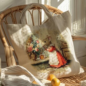 Pu&ograve; includere: Borsa tote in tela beige con un'illustrazione vintage di un topo con un vestito rosso e un grembiule bianco. Il topo &egrave; vicino a un tavolo con fiori e bottiglie. La borsa ha due manici ed &egrave; su una sedia di vimini.