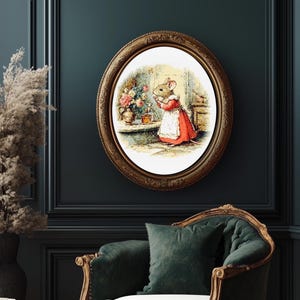 Pu&ograve; includere: Una stampa ovale incorniciata raffigura un topo con un vestito rosso e un grembiule bianco, che si prende cura dei fiori. La stampa ha una cornice color oro ed &egrave; montata su una parete verde acqua scuro. Un vaso e una sedia decorativi sono in primo piano.