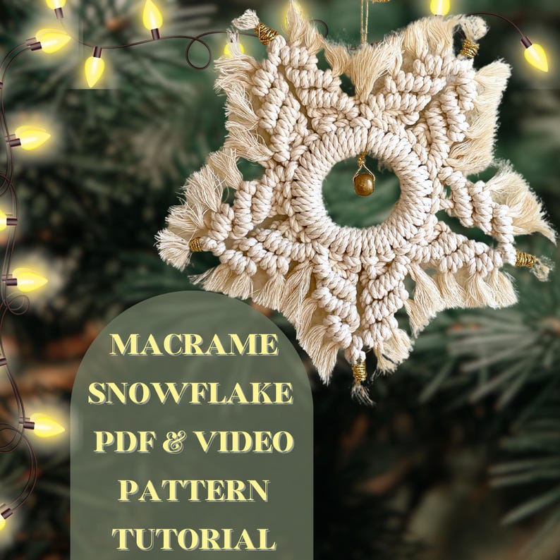 Peut inclure: Une d&eacute;coration de No&euml;l en forme de flocon de neige en macram&eacute; blanc avec une perle dor&eacute;e suspendue au centre. La d&eacute;coration est suspendue &agrave; une branche d'un sapin de No&euml;l avec des lumi&egrave;res blanches.