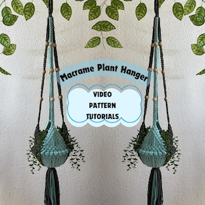 Peut inclure: Deux suspensions de plantes en macramé avec des perles en bois et des cordons noirs et bleus. Les suspensions sont suspendues au plafond et contiennent des plantes. Le texte "Macrame Plant Hanger" et "VIDEO PATTERN TUTORIALS" est visible sur l'image.
