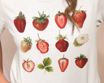 May include: A white t-shirt with a graphic print of red strawberries. The strawberries are arranged in a grid pattern and are depicted in various stages of ripeness.