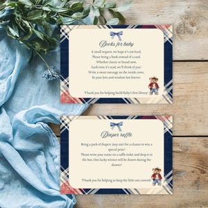 May include: Two cards with a blue and red tartan pattern. The top card says "Books for baby" and has a blue bow. The bottom card says "Diaper raffle" and has a blue bow. Both cards feature a cartoon bear wearing a red shirt and blue jeans.