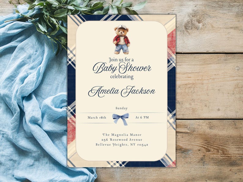 May include: A baby shower invitation with a blue and red tartan pattern. The invitation features a cartoon teddy bear wearing a blue shirt and jeans. The text on the invitation reads "Join us for a Baby Shower celebrating Amelia Jackson. Sunday, March 18th at 6 PM. The Magnolia Manor, 256 Rosewood Avenue, Bellevue Heights, NY 10542."