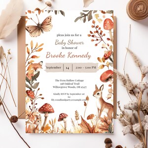 May include: Baby shower invitation featuring watercolor illustrations of woodland animals, mushrooms, and foliage. The invitation includes the text "Baby Shower in honor of Brooke Kennedy" and event details. The color palette includes shades of brown, orange, and beige.