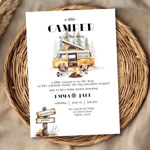 Könnte beinhalten: Eine Babyparty-Einladung mit einer Aquarell-Illustration eines gelben Wohnmobils in einer Waldlandschaft. Der Text lautet "Ein kleiner Camper ist unterwegs" und enthält Details zur Veranstaltung, wie Datum, Uhrzeit und Ort.