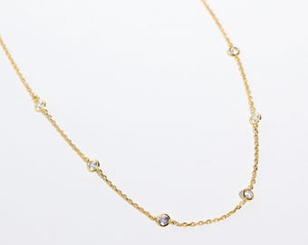 May include: A delicate gold chain necklace with small clear stones spaced evenly along the chain.