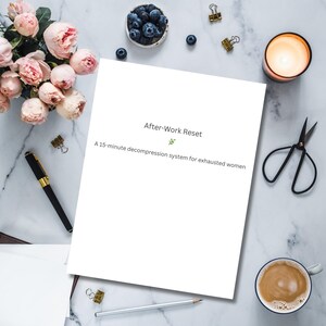 May include: A white sheet of paper with the text "After-Work Reset" and "A 15-minute decompression system for exhausted women" is surrounded by a pen, scissors, a candle, a cup of coffee, and flowers on a marble surface.