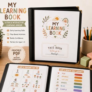 May include: An open black binder with the title "MY LEARNING BOOK" on the cover. Inside, pages display numbers, colors, and educational activities for toddlers. The binder includes a parent guide and is designed for ages 1-3.
