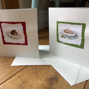 Tarjetas de felicitación con pudines y tartas pintadas a mano, montadas en papel estampado sobre una tarjeta de color blanco roto y con sobre.