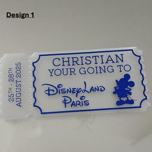 May include: A white ticket-shaped souvenir with blue text and a blue outline. The text reads "CHRISTIAN YOUR GOING TO Disneyland Paris" with a Mickey Mouse silhouette. The left side of the ticket has the dates "25TH - 28TH AUGUST 2025".