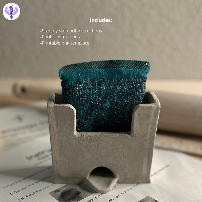 May include: A gray castle-shaped mold with a teal fabric square inside. The mold is used for making a clay castle. The image includes the text "Includes: -Step by step pdf instructions -Photo instructions -Printable png template".