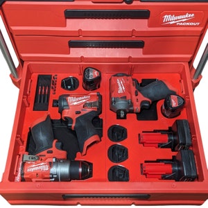 May include: Red Milwaukee Packout tool box with a variety of tools and batteries. The tools include a drill, impact driver, and impact wrench. The batteries are all Milwaukee brand.