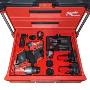 May include: An open red Milwaukee Packout tool box with a variety of tools and accessories inside, including two Milwaukee power drills, batteries, and a set of drill bits.