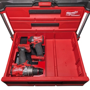 May include: Open red Milwaukee Packout toolbox with three power tools inside. The tools are red and black, and the toolbox is open, revealing the interior compartments. The Milwaukee logo is visible on the tools and the toolbox.