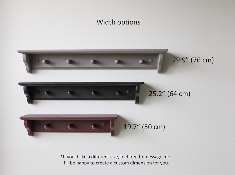 May include: Three wooden wall shelves with pegs in gray, black, and burgundy. The shelves are 29.9" (76 cm), 25.2" (64 cm), and 19.7" (50 cm) wide. Text: Width options. If you'd like a different size, feel free to message me.