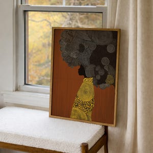 Pu&ograve; includere: Stampa artistica incorniciata raffigurante la silhouette di una persona con un grande afro strutturato. La figura indossa un capo con fantasia gialla e nera. Lo sfondo &egrave; di colore marrone caldo.