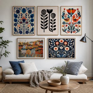 Puede incluir: Una pared de galer&iacute;a con cinco l&aacute;minas de arte enmarcadas: un patr&oacute;n floral azul, un dise&ntilde;o bot&aacute;nico en blanco y negro, una colorida ilustraci&oacute;n de p&aacute;jaros y flores, un paisaje de casas junto a un r&iacute;o y un estampado floral azul oscuro.