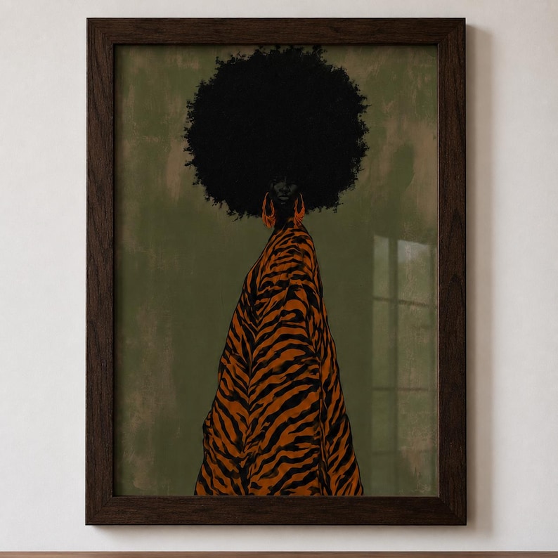 May include: A framed wall art print featuring a person with a large afro hairstyle wearing orange hoop earrings and a long, flowing garment with a black and orange tiger stripe pattern against a muted olive green background.
