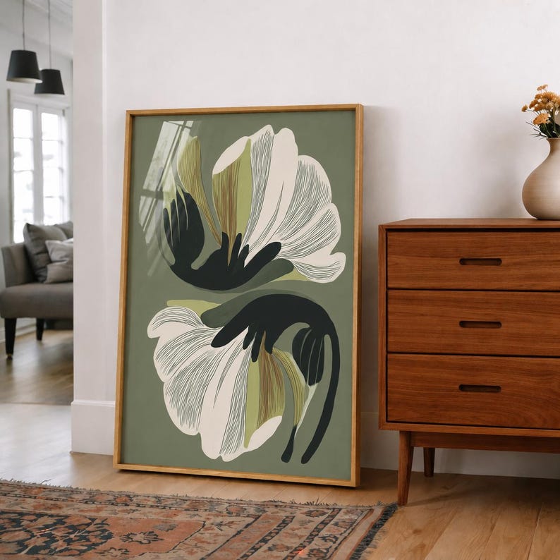 Puede incluir: Una impresi&oacute;n art&iacute;stica enmarcada con un dise&ntilde;o floral estilizado. La obra de arte muestra dos grandes flores abstractas en blanco y verde oliva sobre un fondo verde apagado. El marco es de color madera natural, complementando los tonos terrosos de la obra.