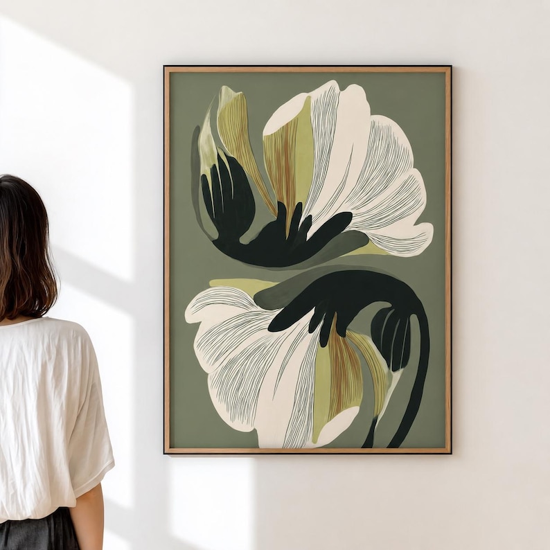 Puede incluir: Impresi&oacute;n art&iacute;stica floral abstracta con dos grandes flores estilizadas en blanco, negro y verde oliva sobre un fondo verde apagado. La obra de arte est&aacute; enmarcada en un marco de madera natural y delgado.