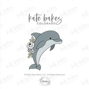 May include: A gray dolphin illustration with white flowers and green leaves. The dolphin is swimming upwards. The text "Kate Bakes Colorado" is at the top. Copyright 2025 Kate Bakes LLC.